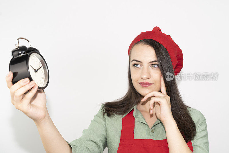 家庭主妇女厨师厨师或面包师围着红色围裙，厨师帽孤立在白色的背景。24、手里牵着微笑的女人round clock快点。模拟复制空间的概念
